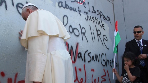 Pope Francis briefly prays at the Israeli separation barrier surrounding three sides of Bethlehem.