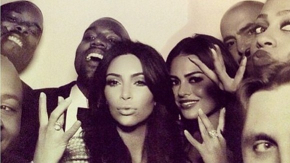 Kanye West Kim Kardashian surrounded by guests in a photo booth at their nuptials.