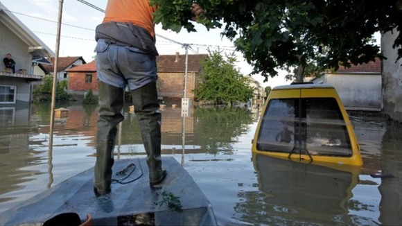 man navigates a boat along a street during heavy floods in Bosnia last week.