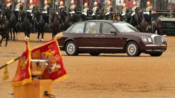 Queen Elizabeth II drives past members of the Household Cavalry before she presents them with new standards at Horse Guards Parade, London