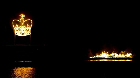 A crown shaped firework is lit behind the Holme Pierrepont Beacon which is floating on the Regatta in Nottingham