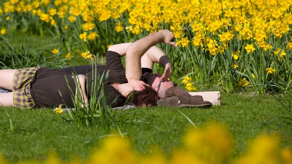 People enjoy sunny weather in Green Park in London.