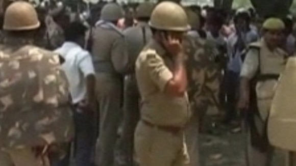 The bodies of the girls hang swaying off the tree yesterday, as the family and supporters protested against the police.