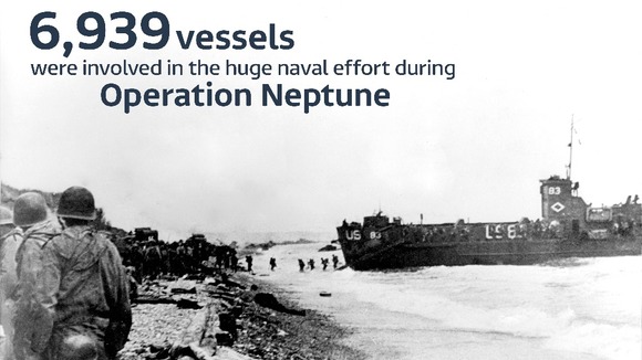 Infantrymen wade to shore under the cover of naval shelling.