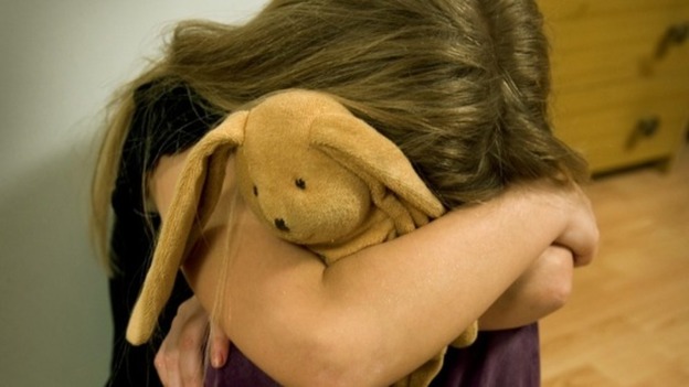 File photo of a girl crying in with cuddly toy.