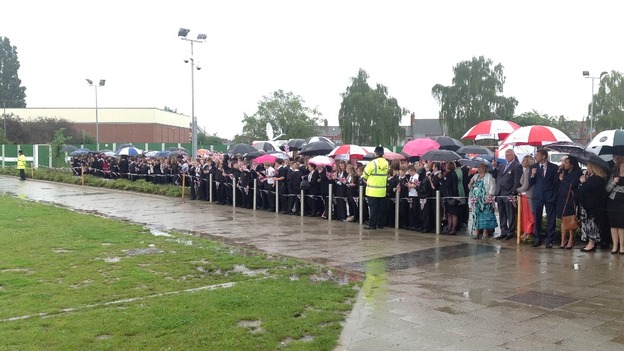 Pupils and staff wait in the rain for Prince William's arrival