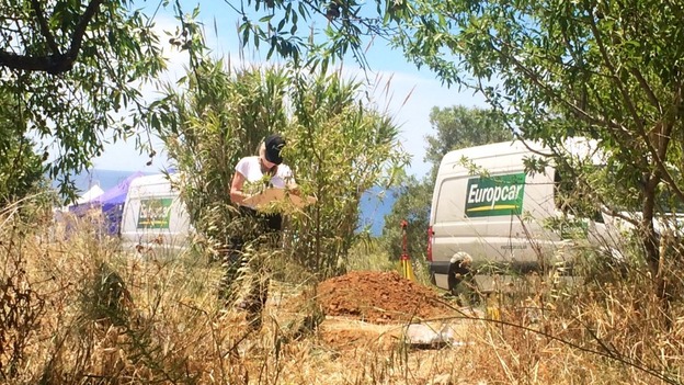 An officer logs notes at the scene while her colleagues have shifted their equipment, and attention, to another spot just a few yards away.