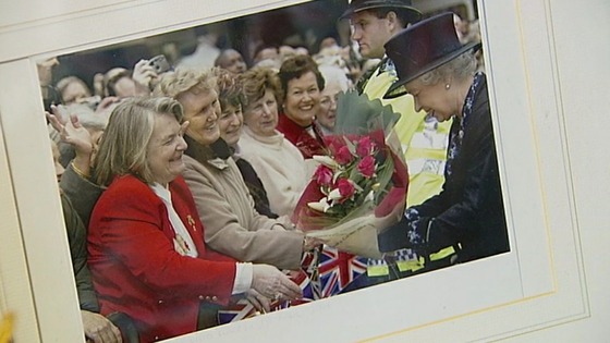 A picture of Margaret handing the Queen a bunch of flowers.