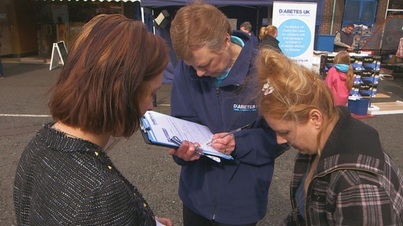 Two women and a man fill out a form