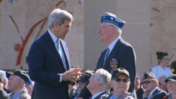 US Secretary of State John Kerry chats to one of the veterans ahead of a memorial service at the US cemetery.