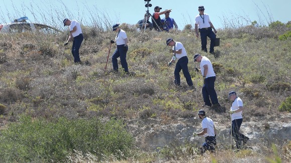 British police officers pictured searching an area of scrubland last week in the hunt for Madeleine McCann.