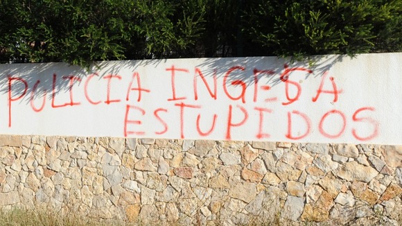 Graffiti scrawled on a wall overlooking the new search site accuses British police of being stupid.