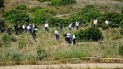 British police and their Portuguese counterparts search a patch of scrubland in the Madeleine McCann investigation.
