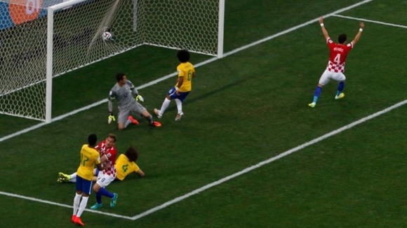 Marcelo, centre, watches as his scuffed clearance hits the back of the net.