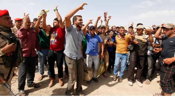 New recruits to the Iraqi army sing and chant before boarding buses to Iraq.