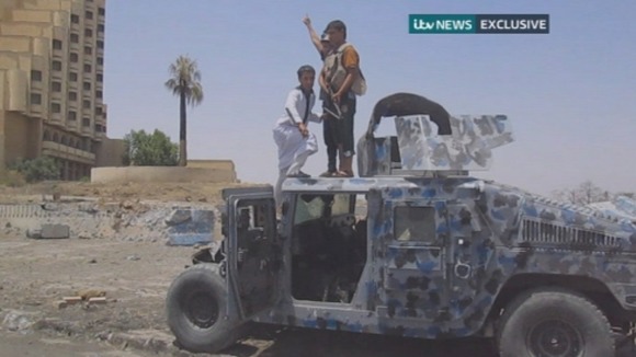 Children clamber on top of a military vehicle in central Mosul.