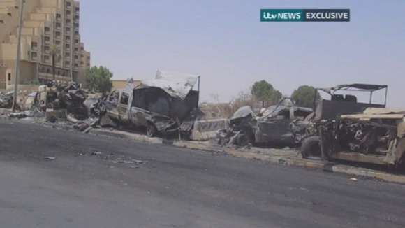 Burnt out vehicles on the side of the road in Mosul.