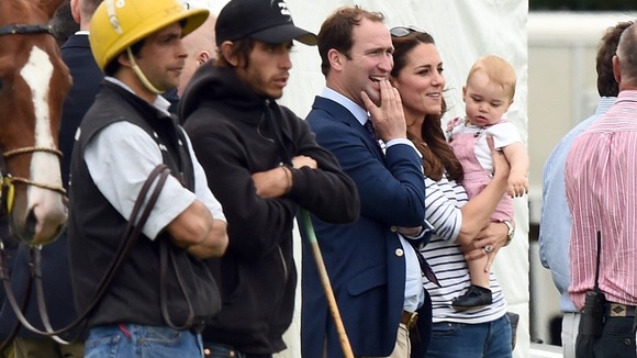 Prince George appears more interested in the grass than watching his father and uncle play polo.