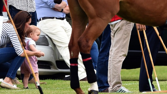 Prince George is looking at horses.