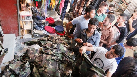 Men buy military kit from a stall in Basra, Iraq.