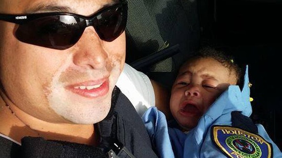 Officer Albert Pizana wrapped Genesis in police uniform upon retrieving her.
