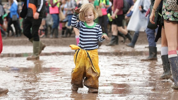 Two-year-old Julia Bristow, from Iowa, USA, walks through a puddle of mud on her first ever Glastonbury visit.