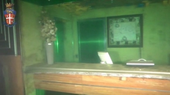 What appears to be a reception point on the ship still shows a vase of flowers, computer and a picture hanging on the wall