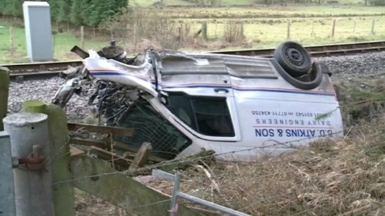 van on side after being hit by train
