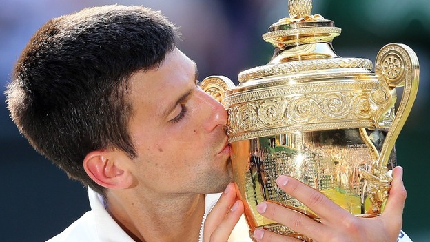 Novak Djokovic kisses the Wimbledon trophy after beating Roger Federer.