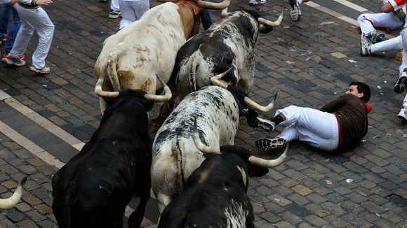 A runner falls in front of the Torrestrella fighting bulls.