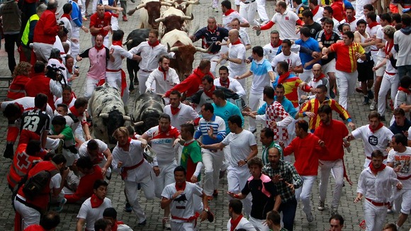 Runners dress in white with red neckerchiefs and many spectators stay up drinking all night in bars beforehand.