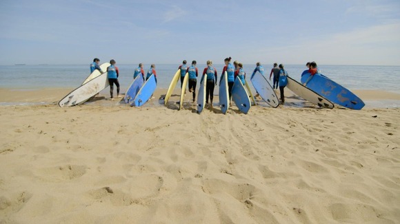 kids with surfboards on the beach