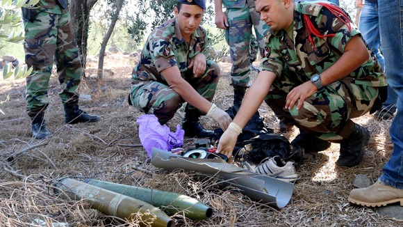 A Lebanese army personnel inspects the remains of a shell in southern Lebanon.