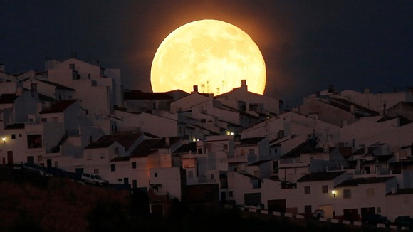 The "supermoon" rises over houses in Olvera, Spain.