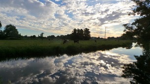 Summer skies reflected in the River Waveney at Bungay in Suffolk.