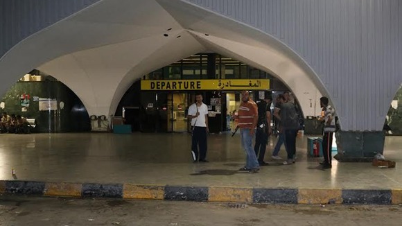 Fighters stand outside the departures terminal at Tripoli's international airport