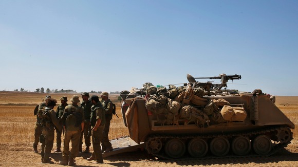 Israeli army reservists stand near an armoured vehicle in the Gaza strip.