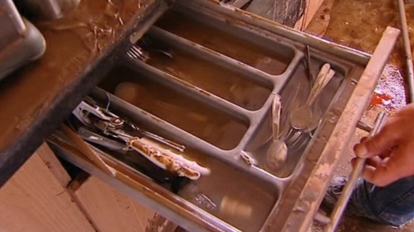 A cutlery drawer filled with dirty flood water