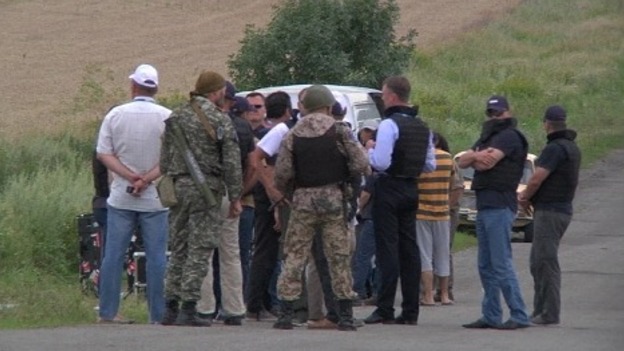 The Organisation for Security and Co-operation in Europe monitoring team stand near the crash site.