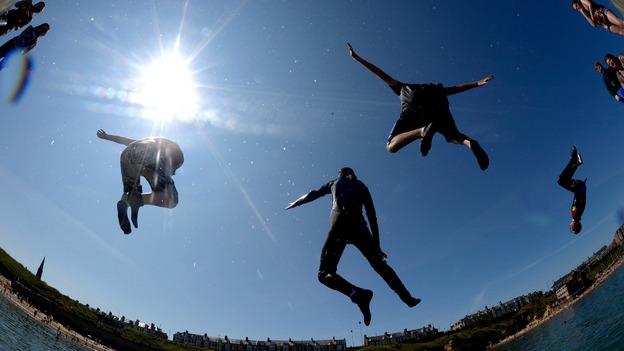 Visitors at Cullercoats, North Tyneside, jump in the water as temperatures reach the high 20s.