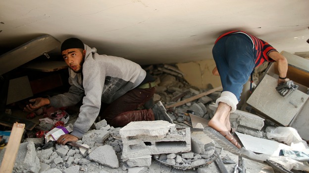 Palestinian boys go through the rubble of their destroyed home in Gaza.