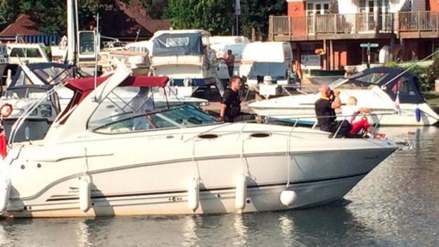 Boat with people searching for boy on River Thames