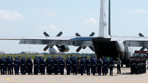 Ukrainian officials attend a farewell ceremony near the transport plane.