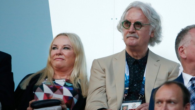 Comedian Billy Connolly his wife Pamela Stephenson sit in the stands during the opening ceremony.