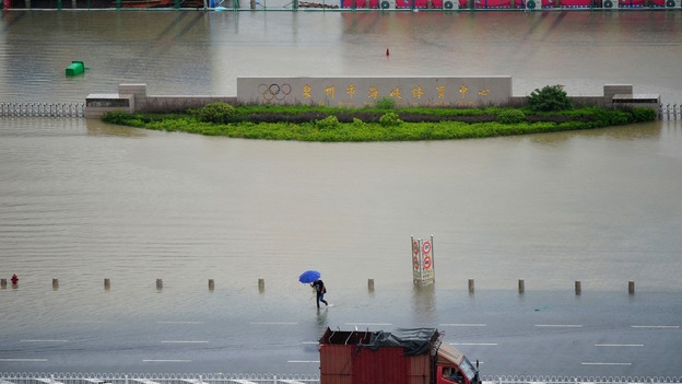 A man wades through a flooded street after the typhoon hit the island of Penghu.