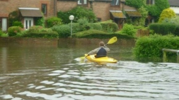 A canoeist makes best use of the conditions in Chaffer Lane, Birdham, West Sussex.