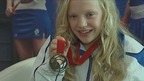 Para-sport swimmer Erraid Davies smiles as she shows her bronze medal.