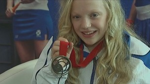 Para-sport swimmer Erraid Davies smiles as she shows her bronze medal.