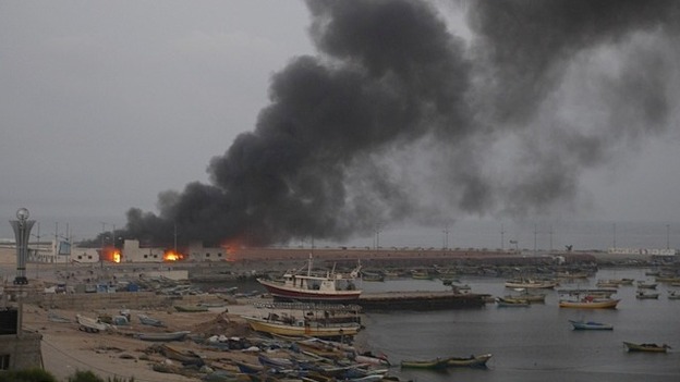 The target of an Israeli strike smoulders at a port on the Gaza coast.