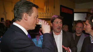 British Prime Minister David Cameron sinks a pint of Guinness.